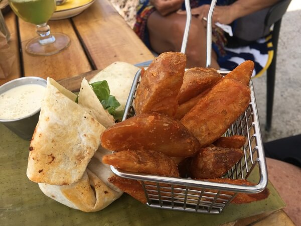 Crispy potato wedges alongside a blackened swordfish caesar wrap.