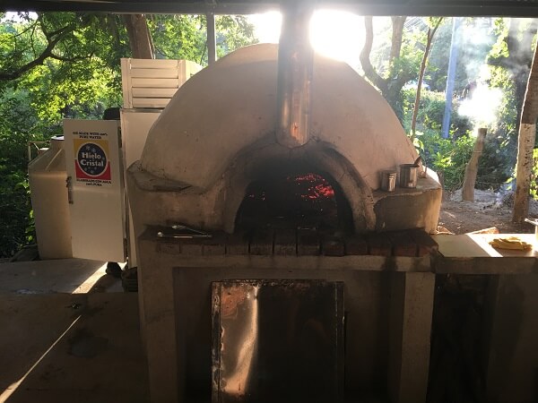 Hot embers in the pizza oven at just the right temperature make the perfect pizza and crust.