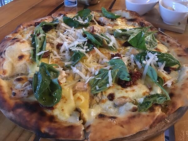 Chicken, garlic, gouda, sun dried tomatoes and fresh basil leaves on top of a thin crunchy crust.