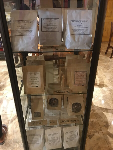 Display case with bags of chocolate nibs and tea.