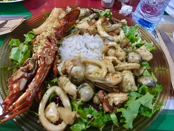 Wonderful combination of various seafood over a nice bed of fresh greens and fluffy white rice.