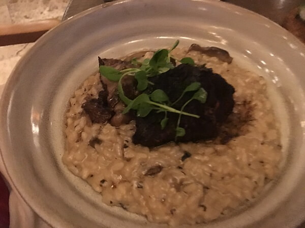 A super tender braised short rib on a bed of risotto.