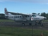 A 12 passenger Cessna Caravan, operated by Sansa Airlines, sits on the tarmac in Tamarindo Costa Rica.