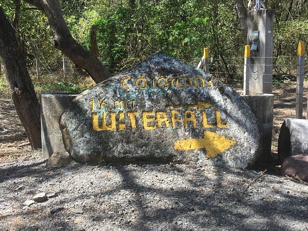 The waterfall entrance is marked with a large rock.